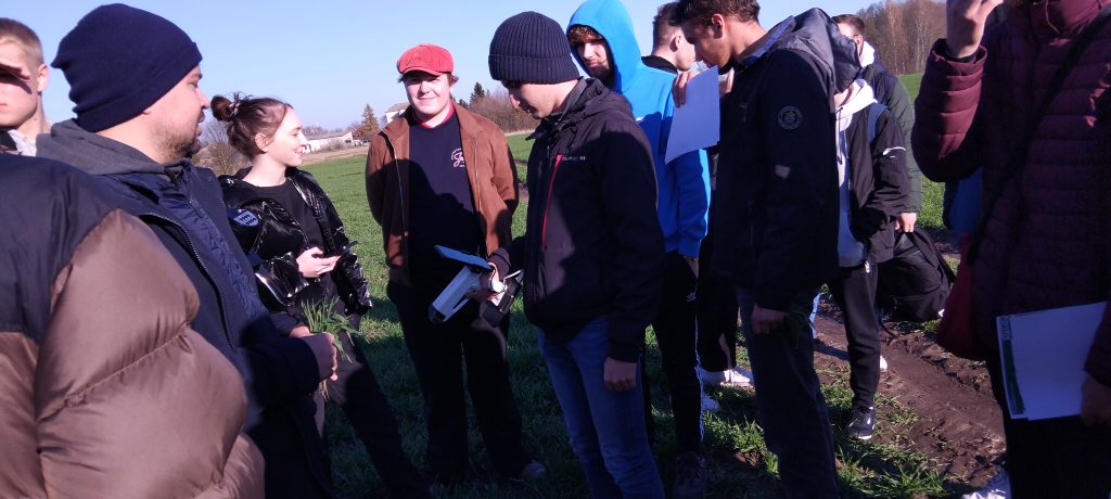 grupa studentów w kurtkach na polu