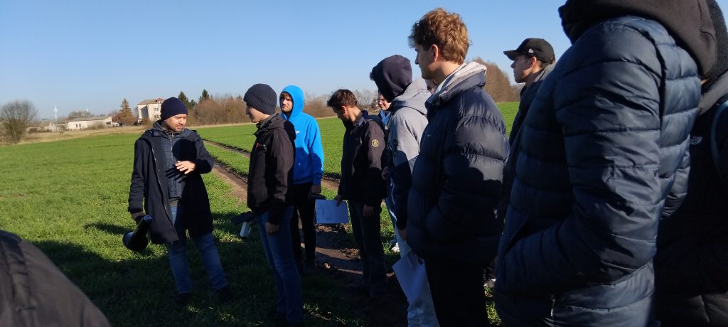 grupa studentów w kurtkach na polu