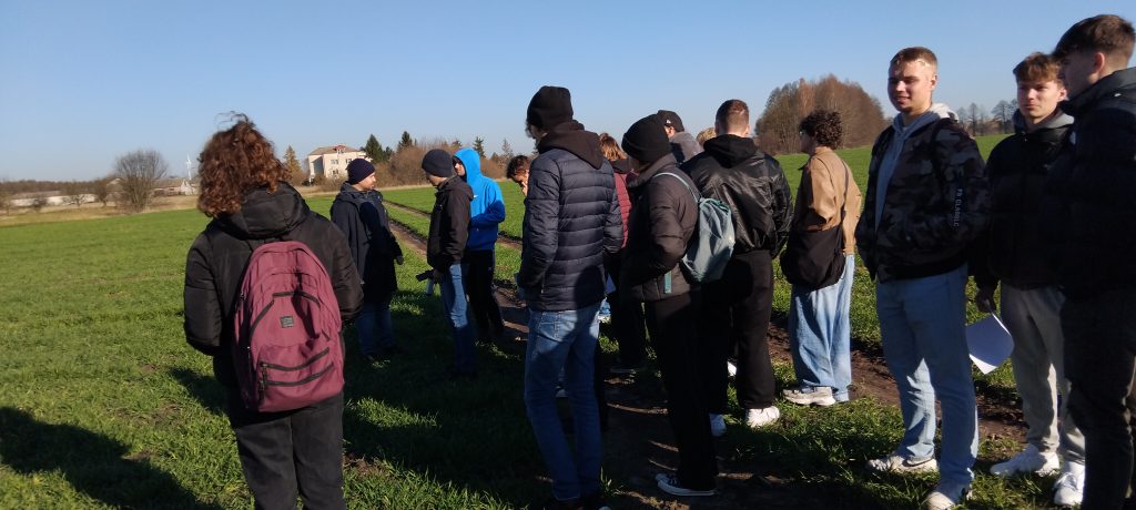grupa studentów w kurtkach na polu
